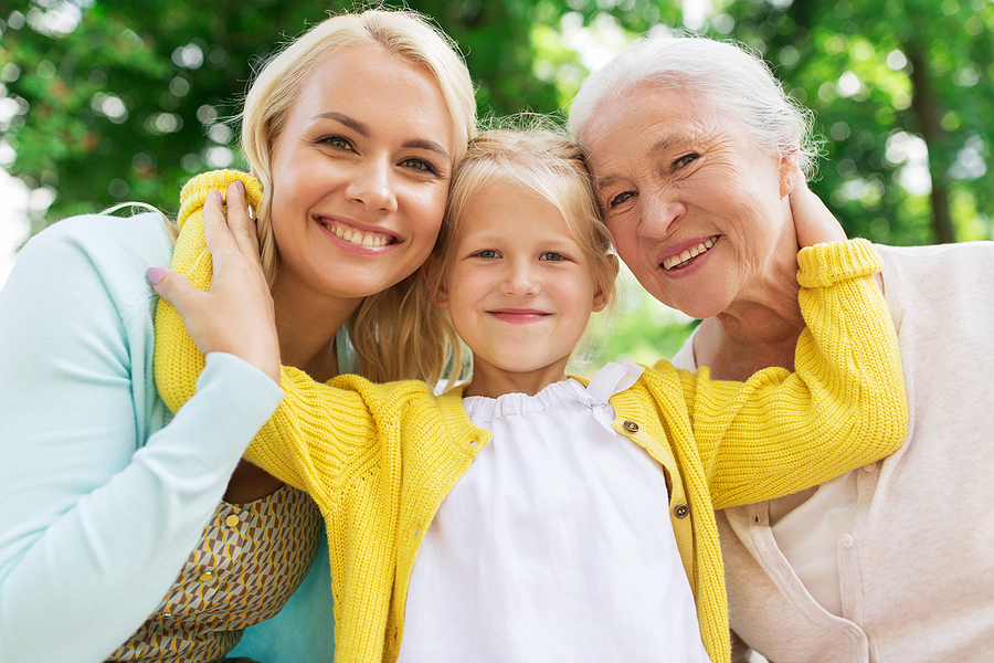 family, generation and people concept - happy smiling woman with daughter and senior mother sitting on park bench